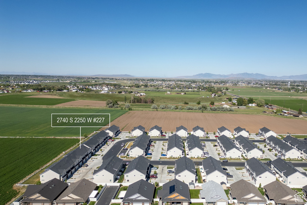 Aerial view of property and surrounding area with nearby suburban area and a mountain backdrop