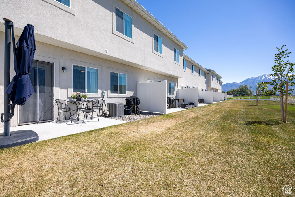 Rear view of house with a mountain view, a patio area, and stucco siding