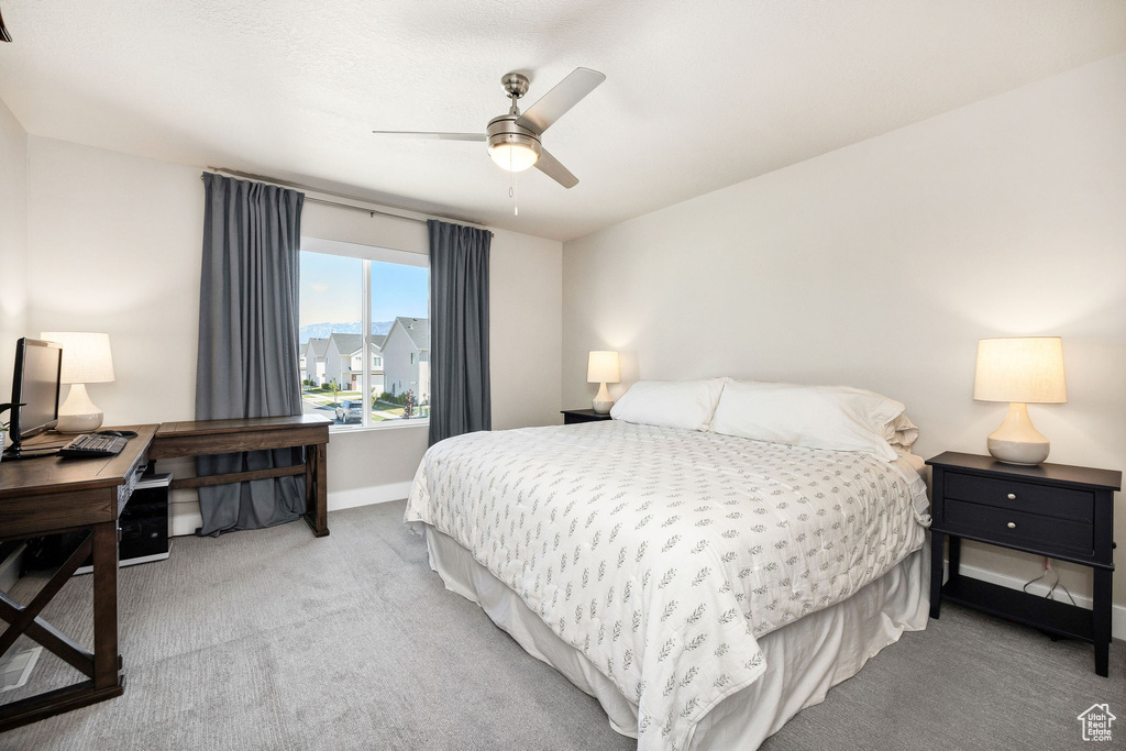 Bedroom with carpet, an office area, baseboards, and ceiling fan