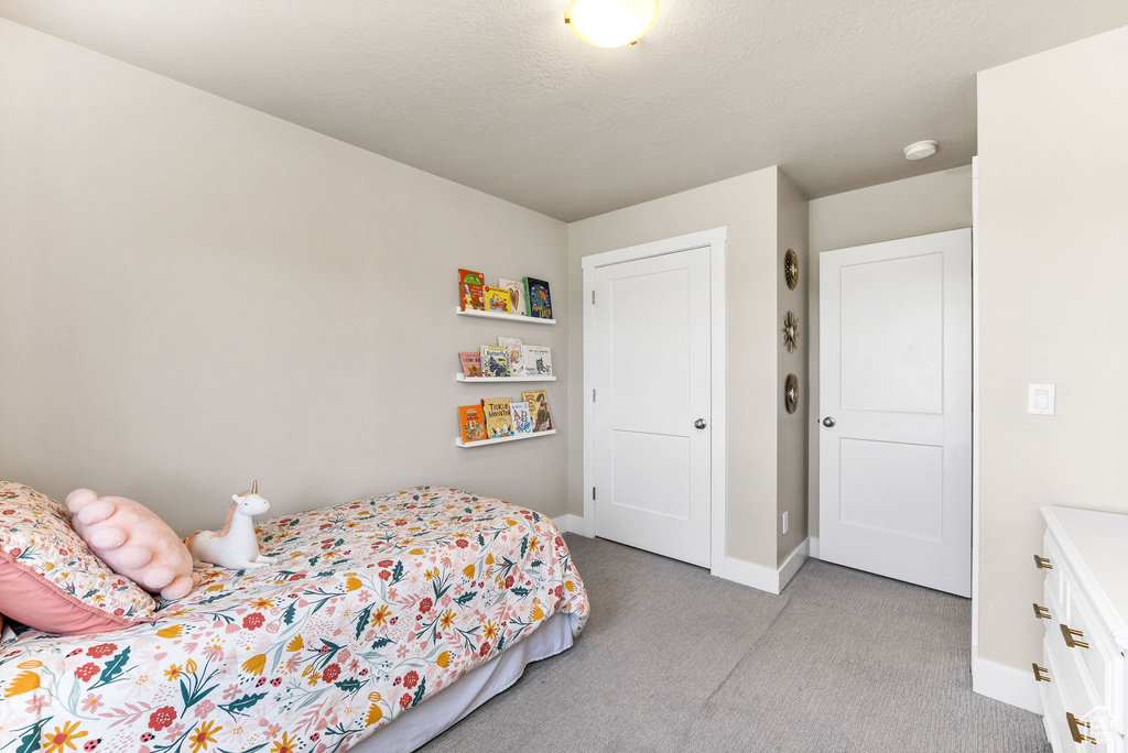 Bedroom featuring light colored carpet and baseboards