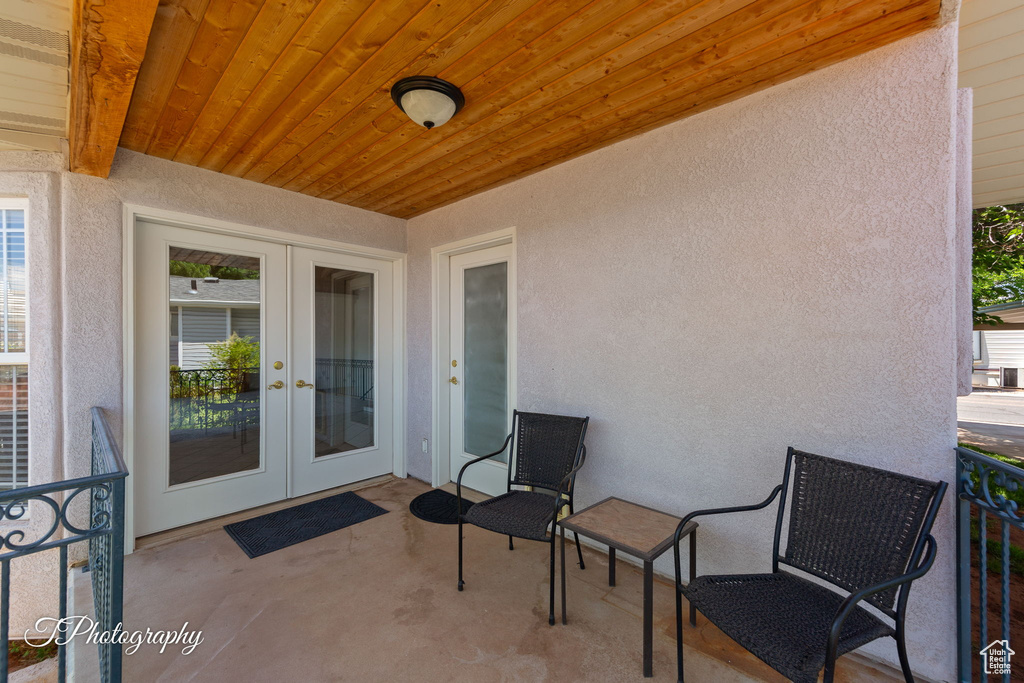 View of exterior entry with french doors, stucco siding, and a patio