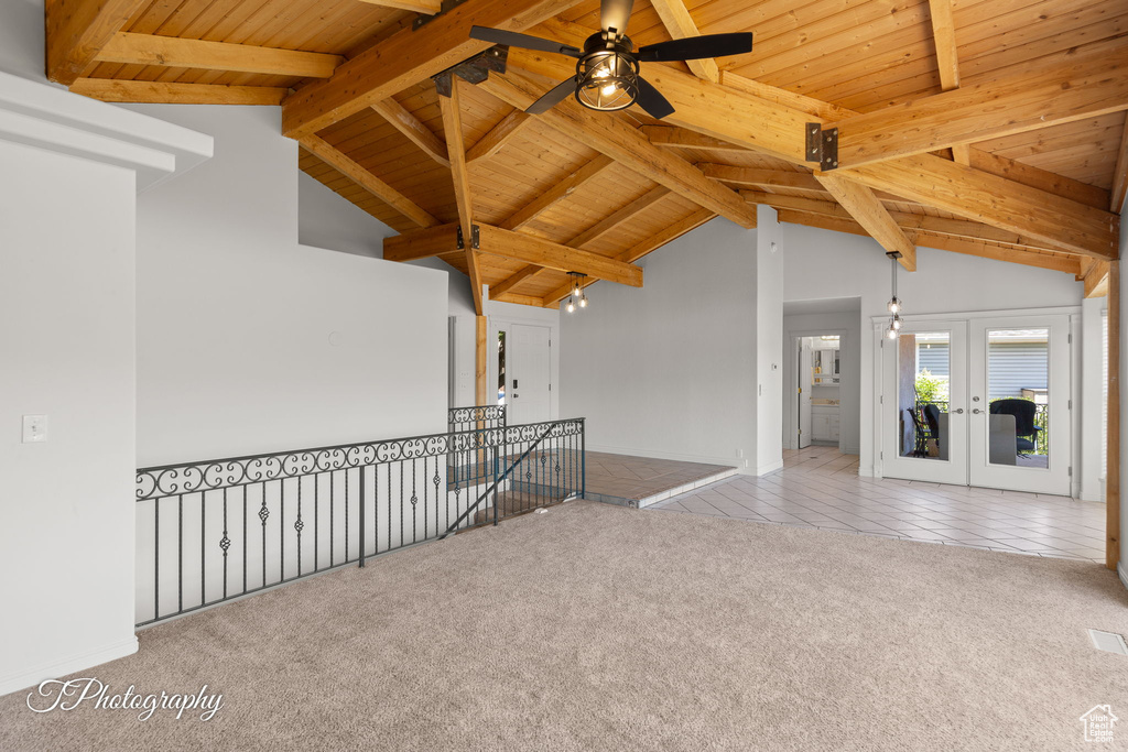Tiled empty room featuring wooden ceiling, carpet floors, a ceiling fan, and french doors