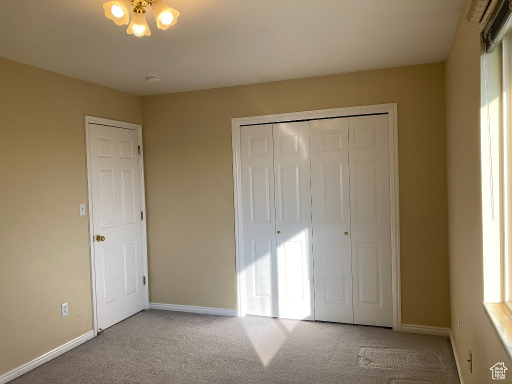 Unfurnished bedroom featuring carpet, baseboards, and a closet