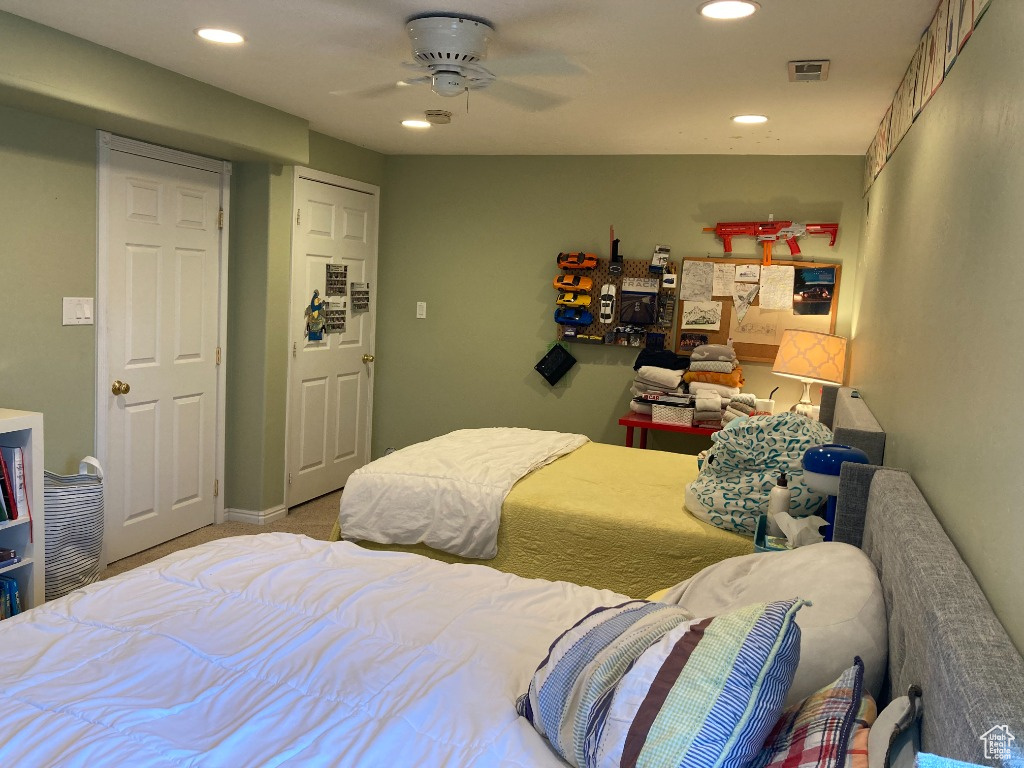 Carpeted bedroom with recessed lighting and ceiling fan