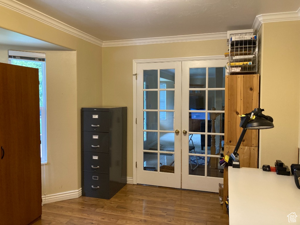 Doorway to outside with french doors, wood finished floors, and crown molding