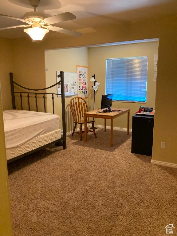 Bedroom with carpet flooring, an office area, baseboards, and ceiling fan