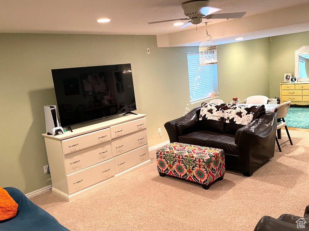 Carpeted living area with a ceiling fan, recessed lighting, and baseboards