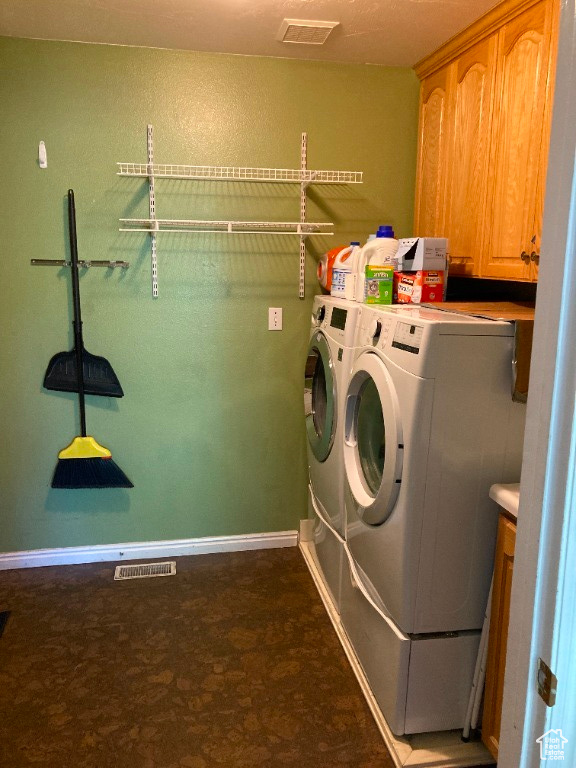 Washroom featuring cabinet space, washing machine and clothes dryer, and baseboards