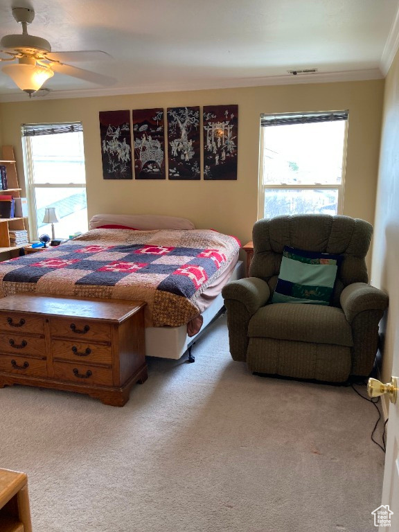Bedroom with crown molding, light colored carpet, multiple windows, and ceiling fan