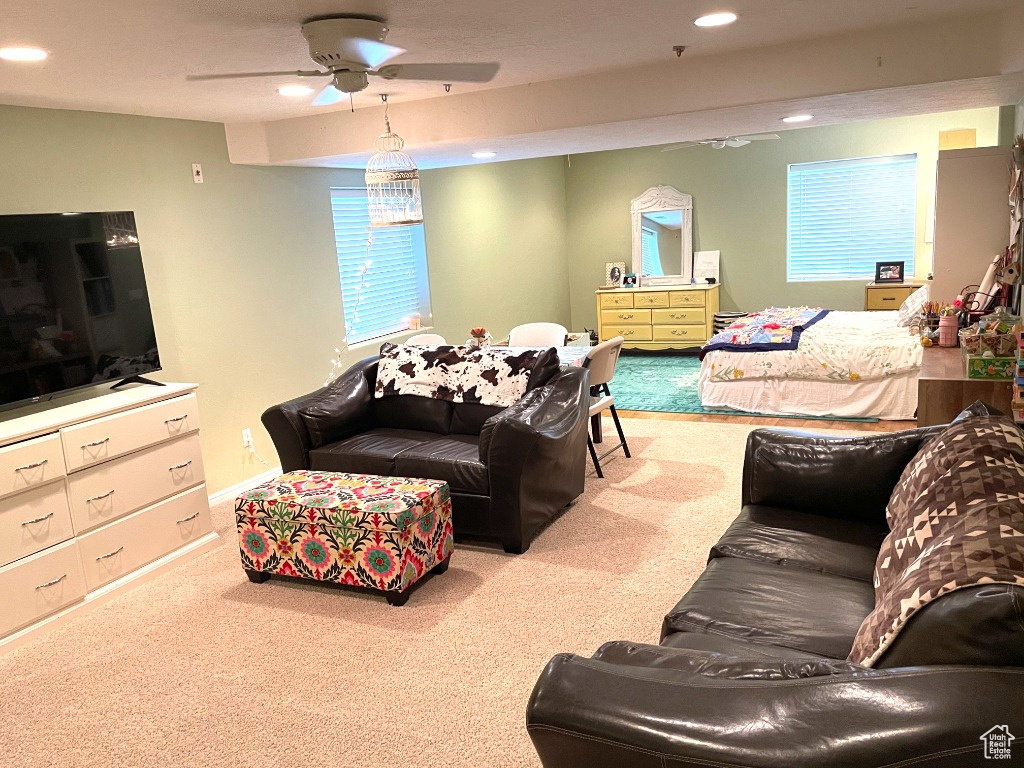 Carpeted living room with a ceiling fan and recessed lighting