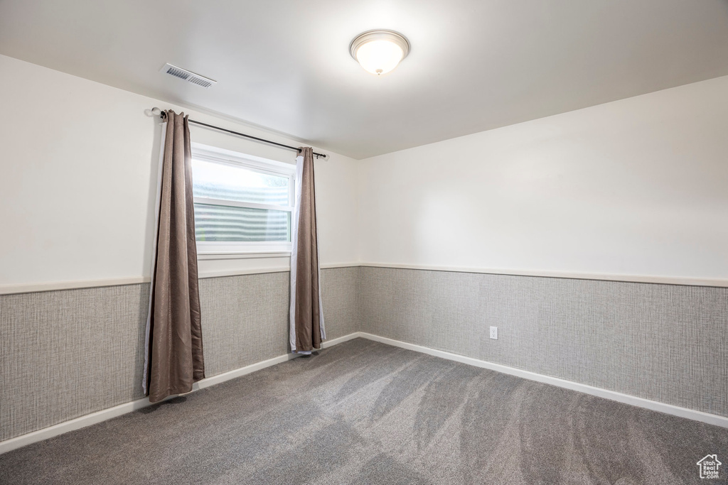 Empty room featuring wainscoting and carpet floors