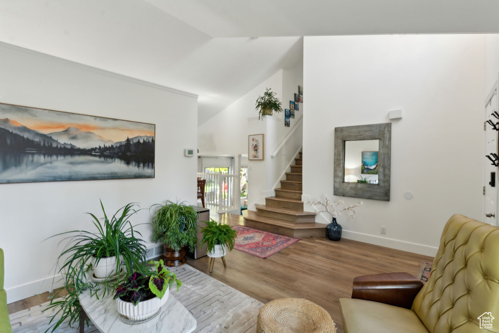 Living area featuring stairs, wood finished floors, and baseboards