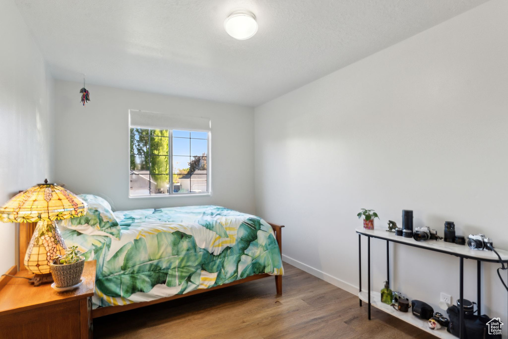 Bedroom with wood finished floors and baseboards