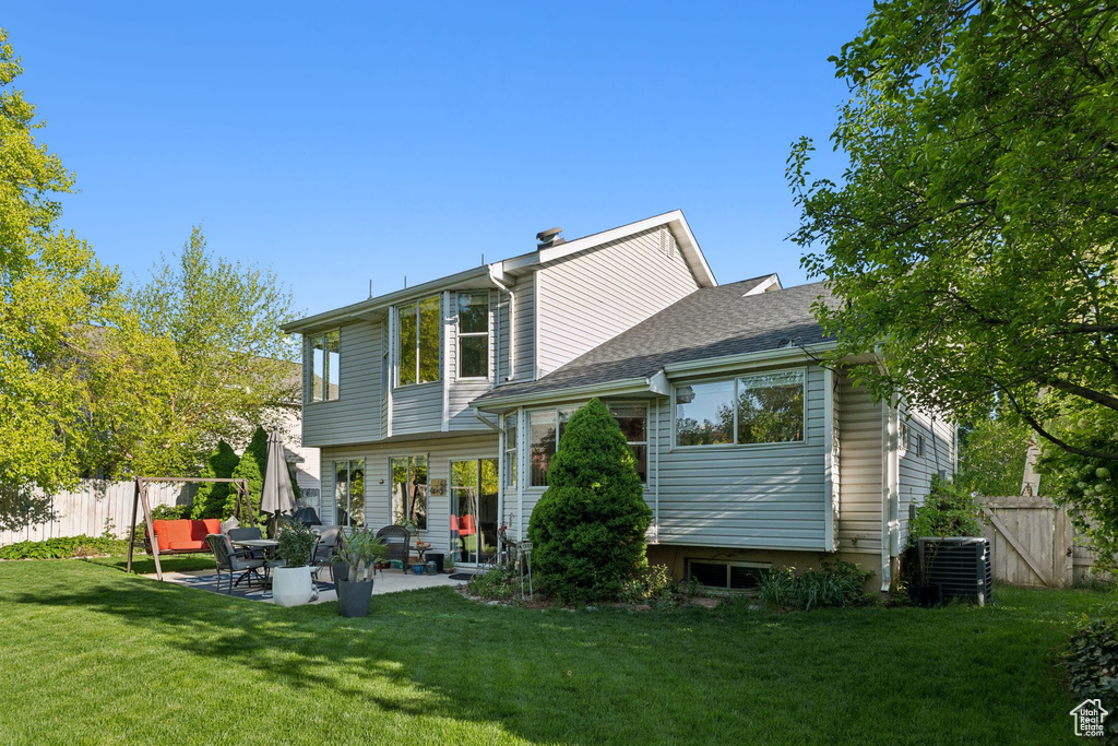 Rear view of house with a patio, central air condition unit, and a shingled roof
