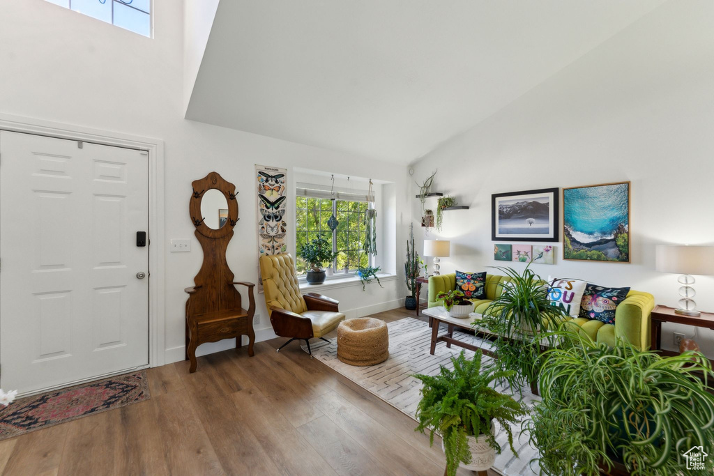 Foyer featuring high vaulted ceiling, wood finished floors, and baseboards