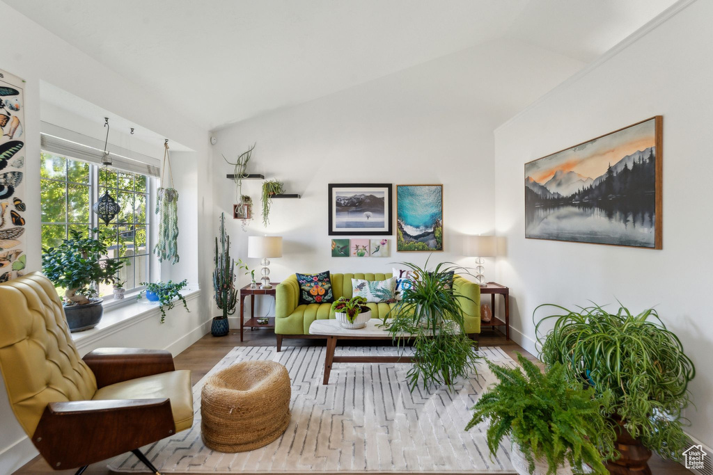 Living area with wood finished floors, lofted ceiling, and baseboards