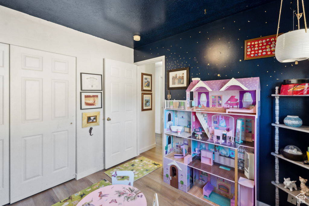Recreation room featuring wood finished floors and baseboards