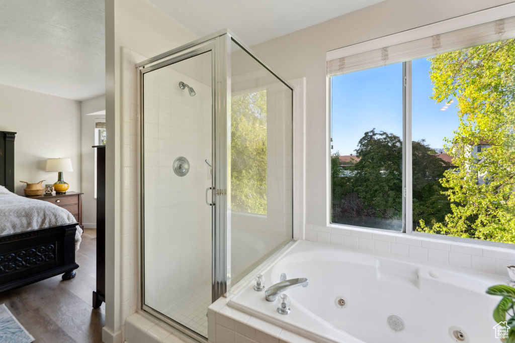 Full bath with connected bathroom, plenty of natural light, and a shower stall