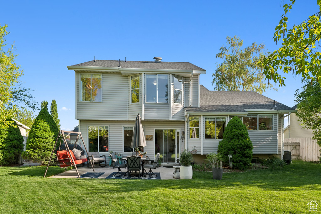 Rear view of property with a patio area and roof with shingles