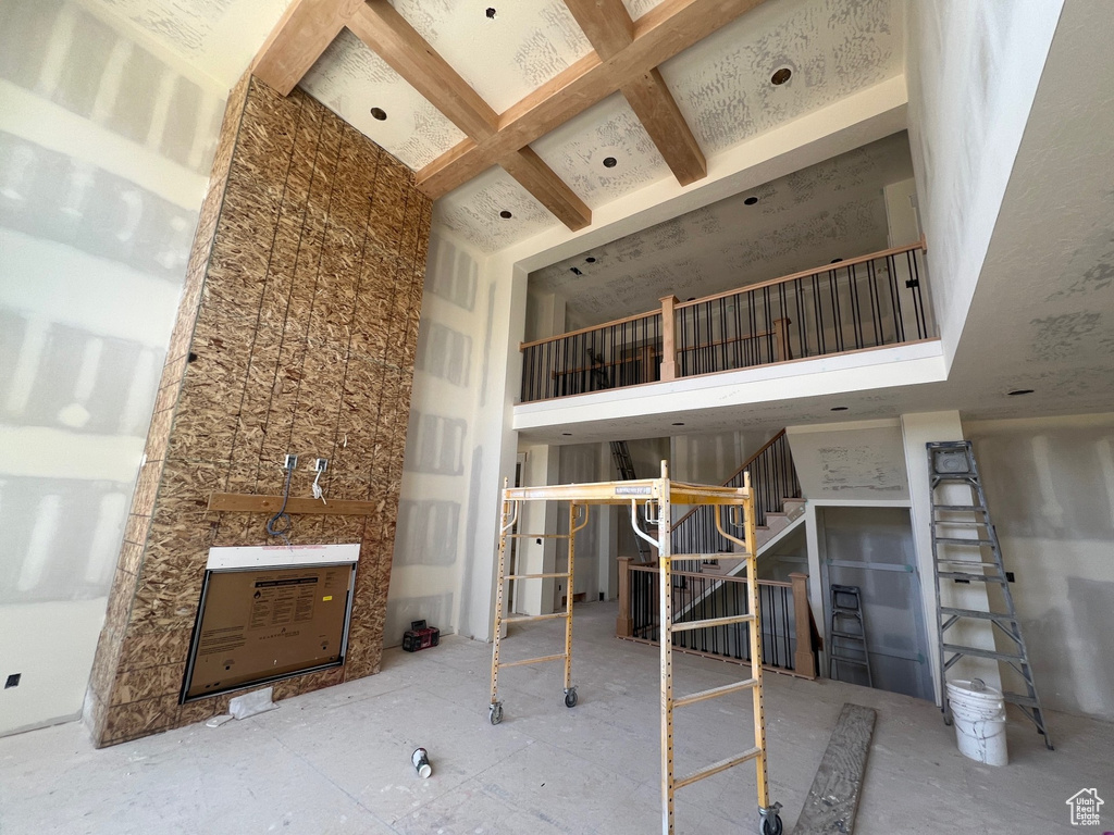 Unfurnished living room featuring stairway and a towering ceiling