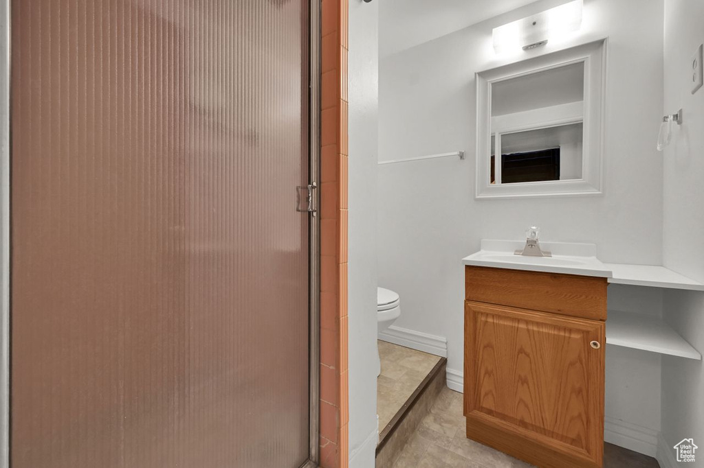 Full bath featuring toilet, a shower stall, and vanity