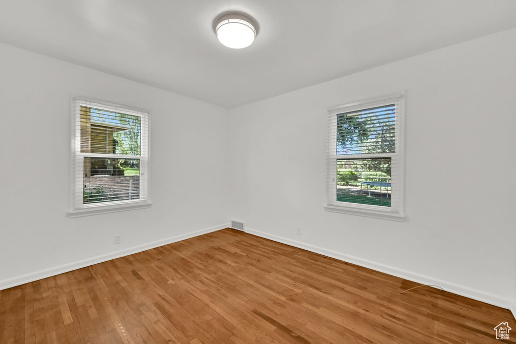 Spare room featuring wood finished floors and baseboards