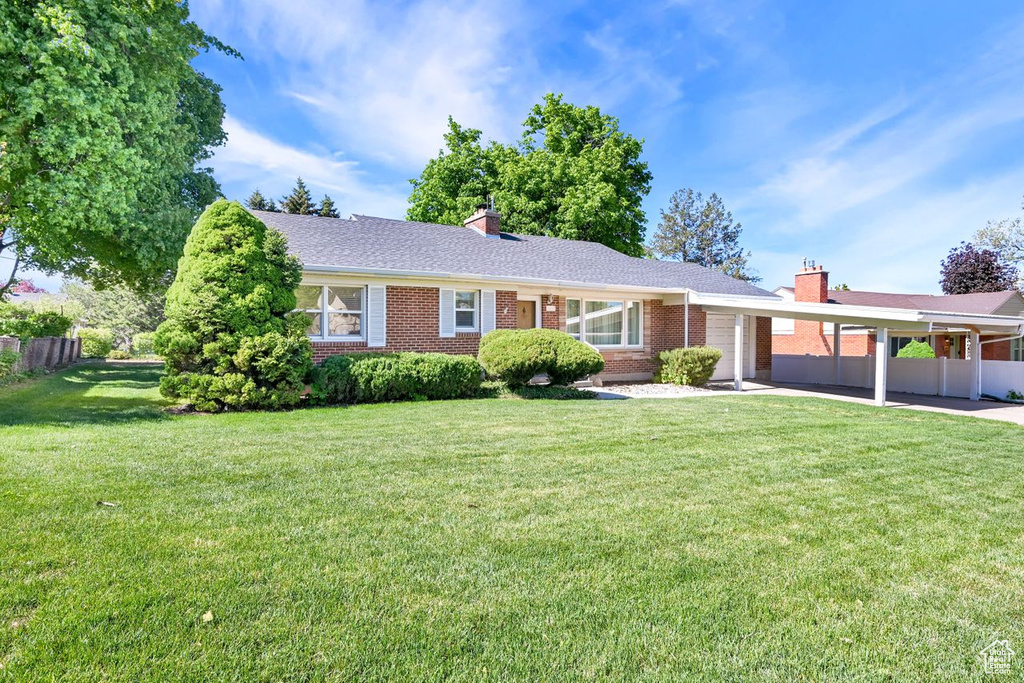 Ranch-style house featuring a chimney and brick siding