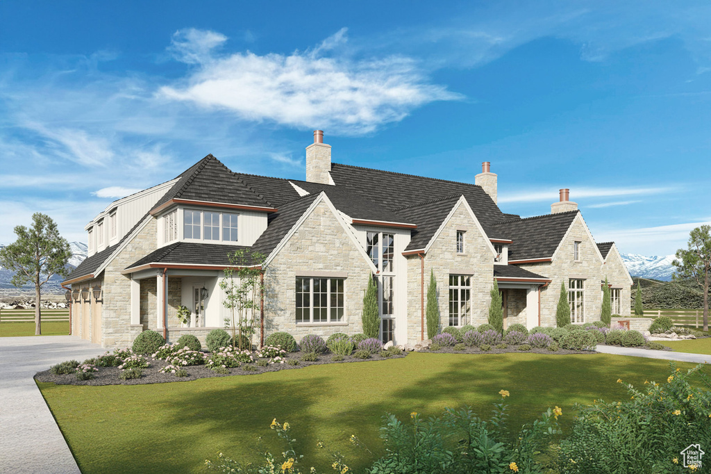 View of front of house with stone siding, a chimney, a front lawn, and driveway