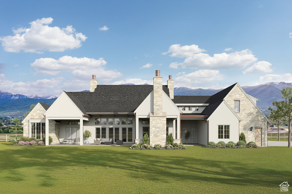 Back of property with stone siding, a mountain view, and a yard