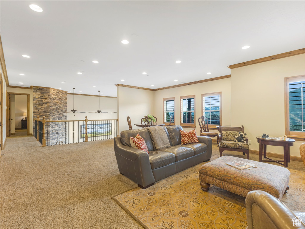 Carpeted living room featuring ornamental molding, recessed lighting, and a ceiling fan