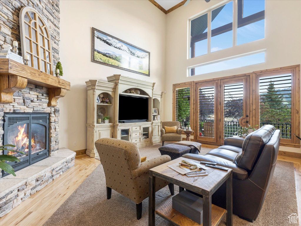 Living room with a high ceiling, a fireplace, and wood finished floors
