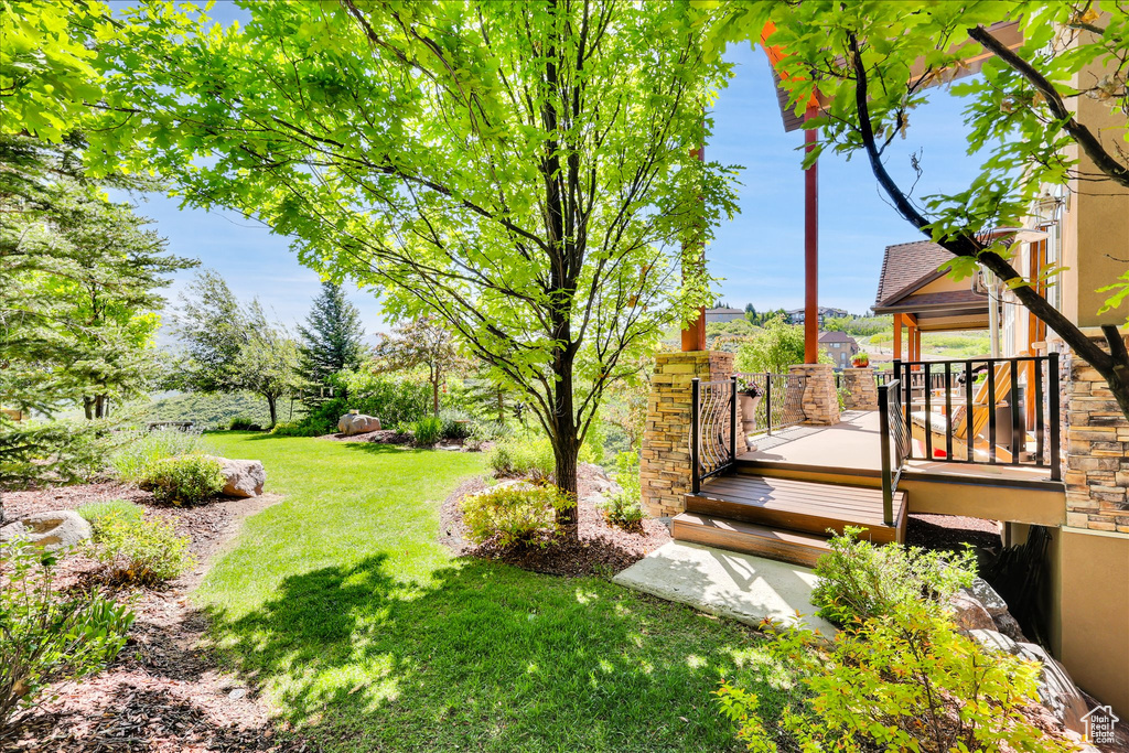 View of grassy yard featuring a wooden deck and a gazebo