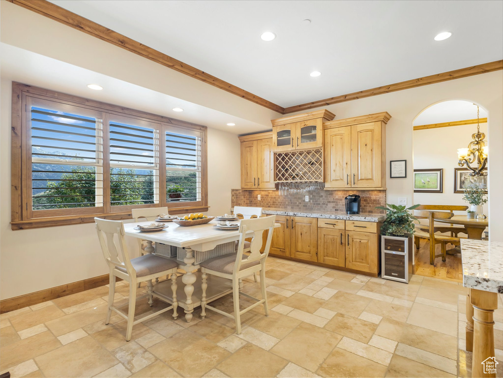 Kitchen with backsplash, recessed lighting, a chandelier, baseboards, and stone tile flooring