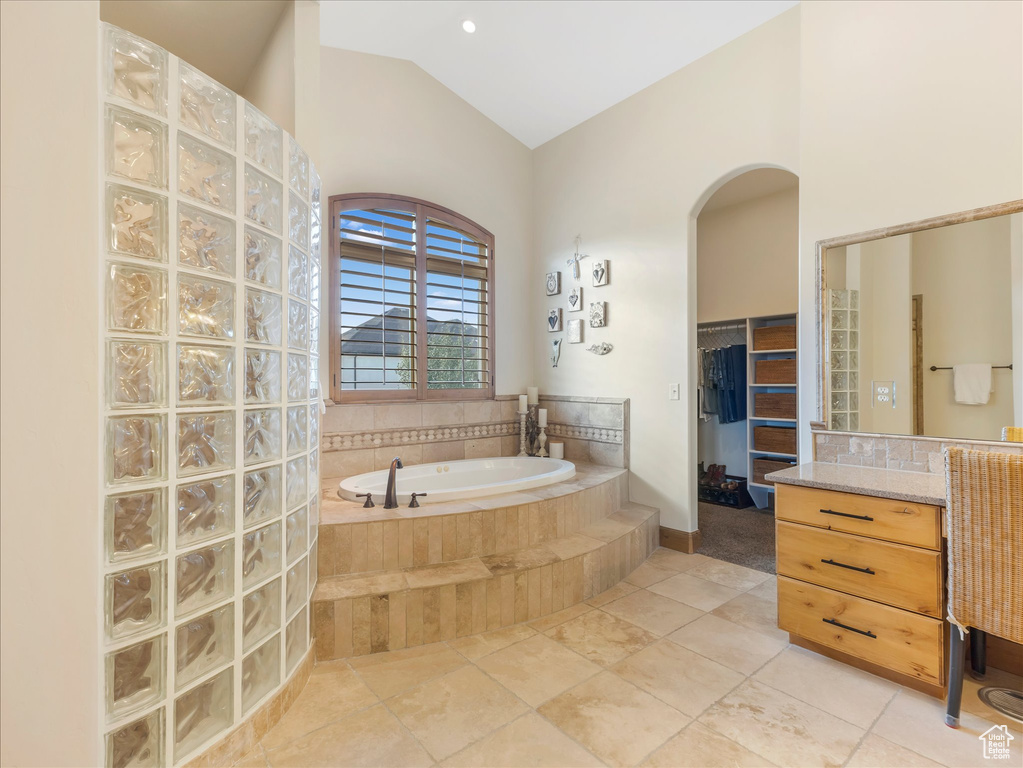 Bathroom featuring a bath and lofted ceiling