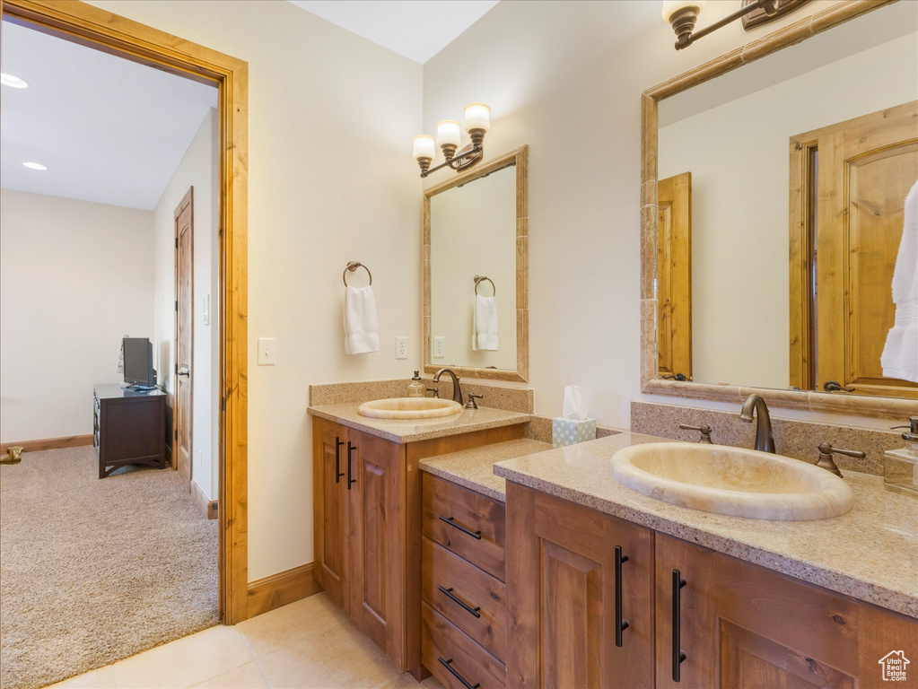 Full bath featuring two vanities, tile patterned floors, baseboards, and recessed lighting