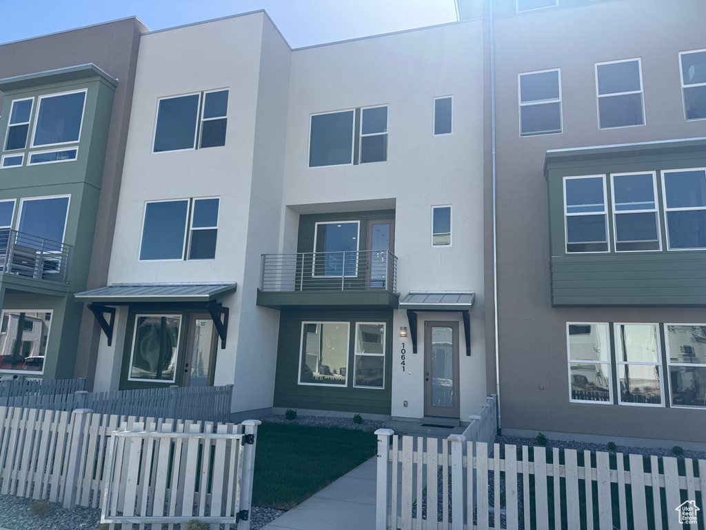 Multi unit property featuring stucco siding, a standing seam roof, metal roof, and a fenced front yard