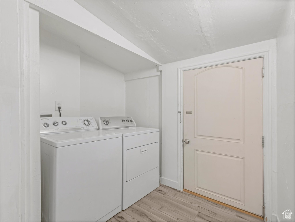 Laundry area featuring independent washer and dryer and light wood finished floors
