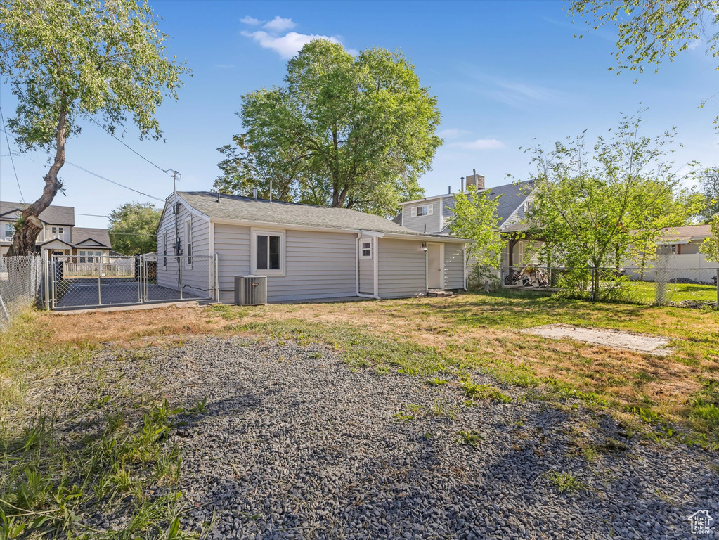 Rear view of property with central air condition unit and a fenced backyard