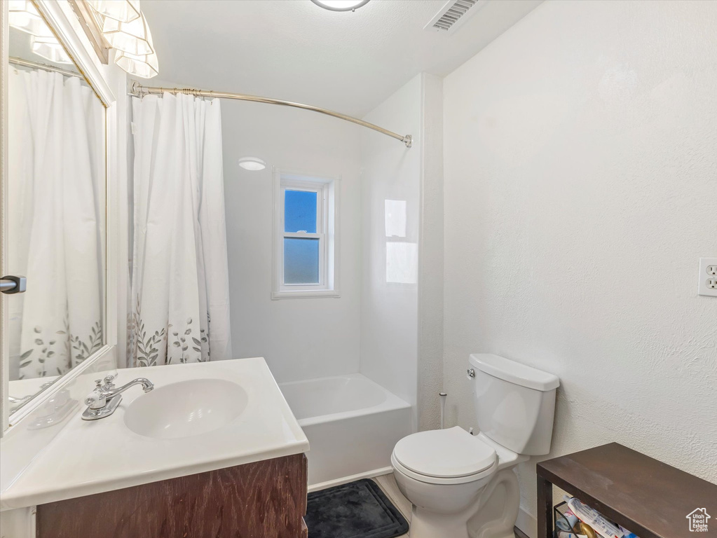 Full bath featuring toilet, vanity, and shower / bath combo with shower curtain