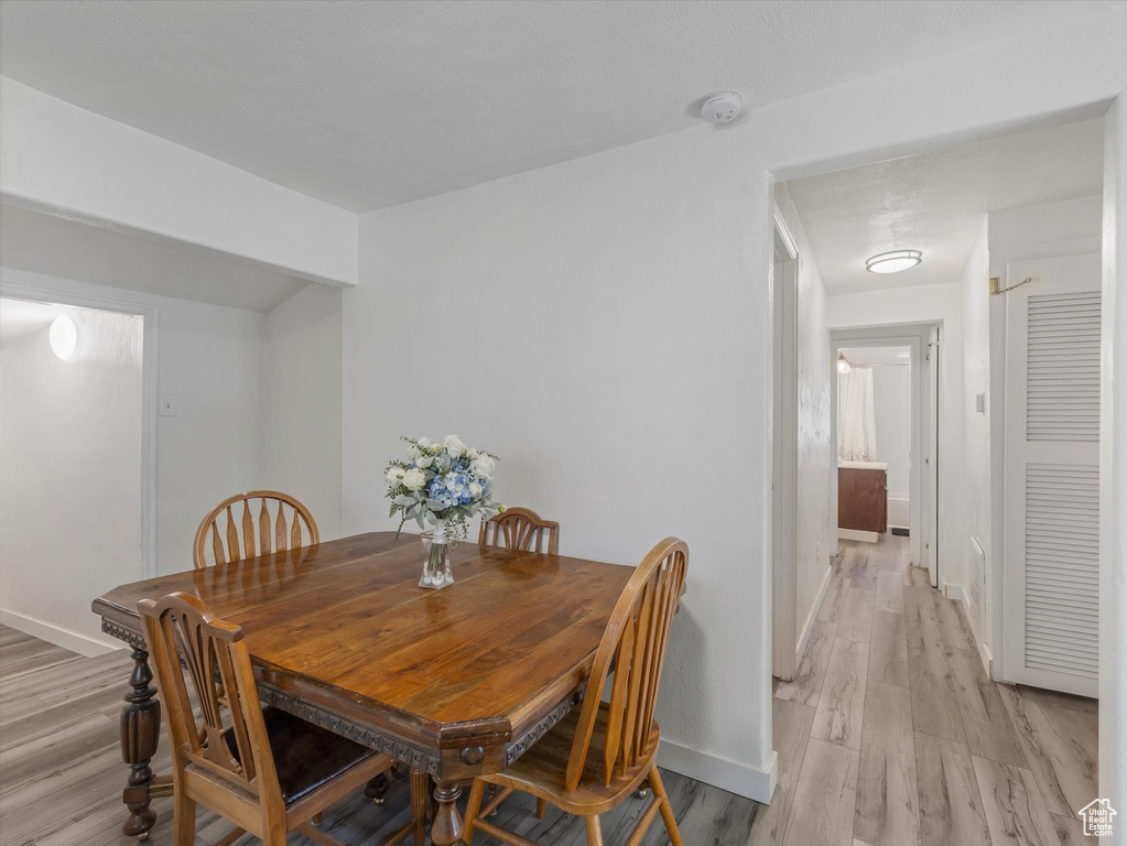 Dining area with baseboards and light wood-style flooring