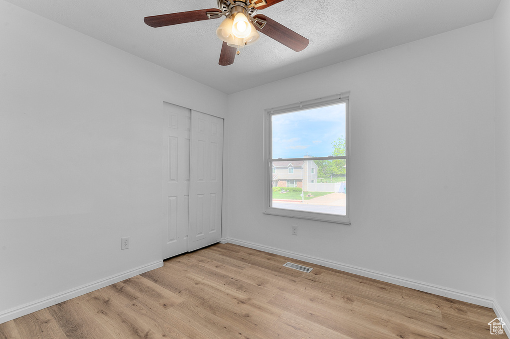 Spare room featuring baseboards, light wood-style flooring, and ceiling fan
