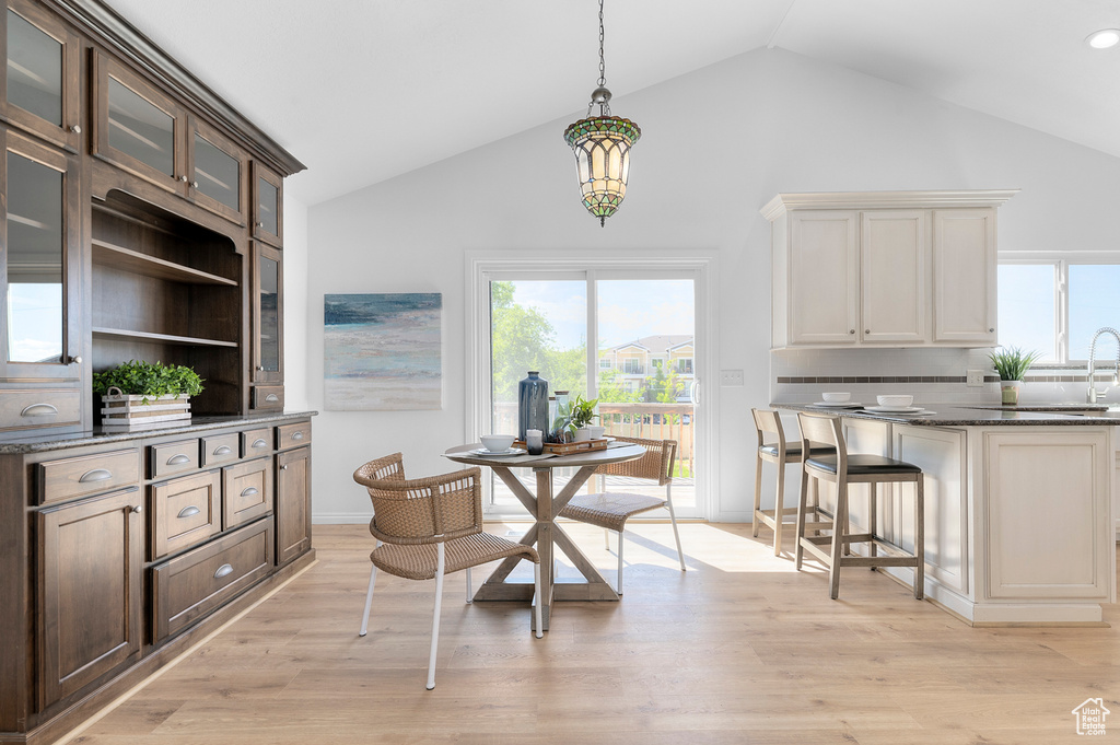Dining room featuring light wood-style flooring and high vaulted ceiling