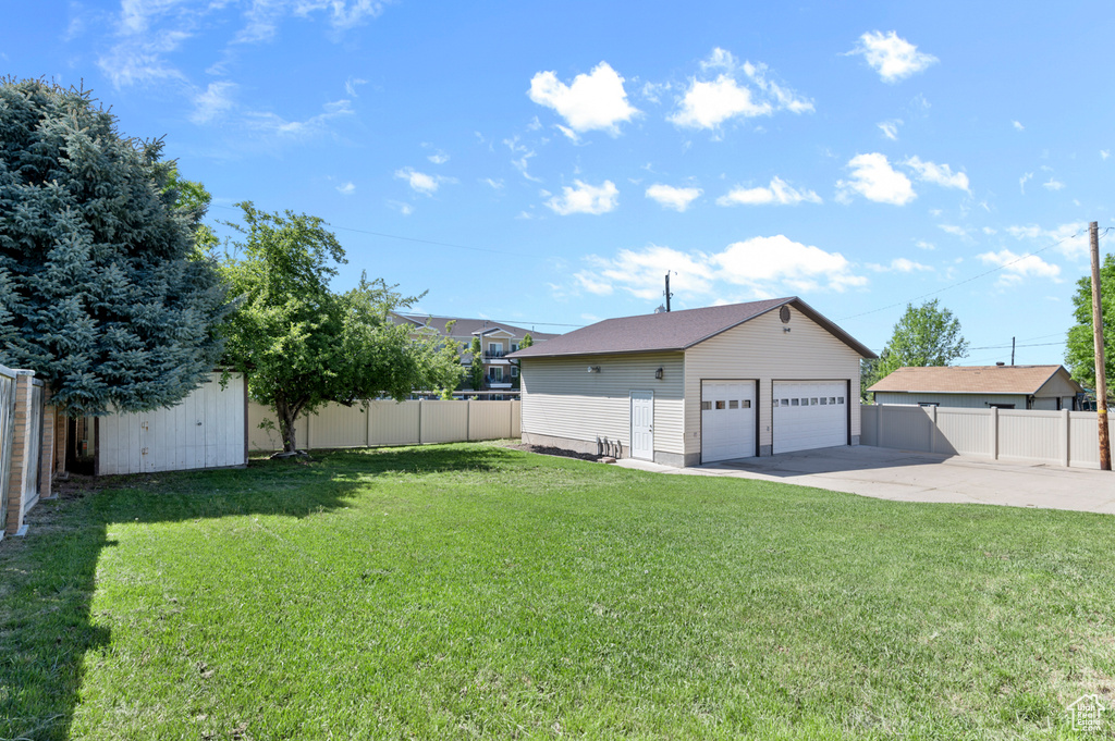 View of yard with an outdoor structure and a detached garage