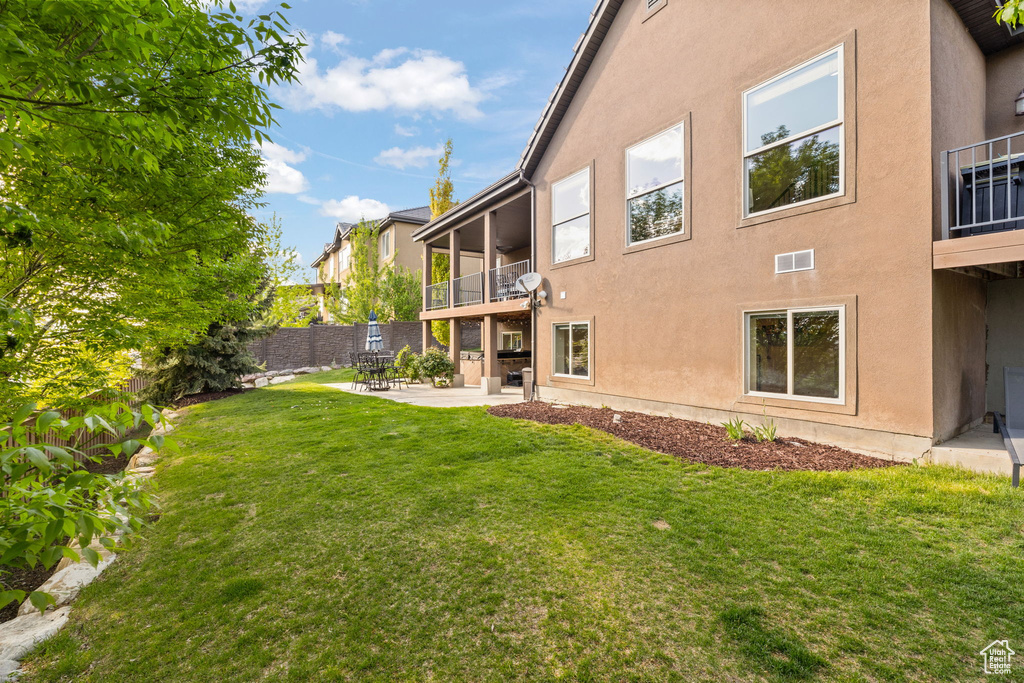 View of yard with a balcony and a patio