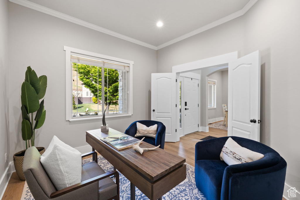 Office space featuring ornamental molding, light wood-style floors, arched walkways, baseboards, and recessed lighting