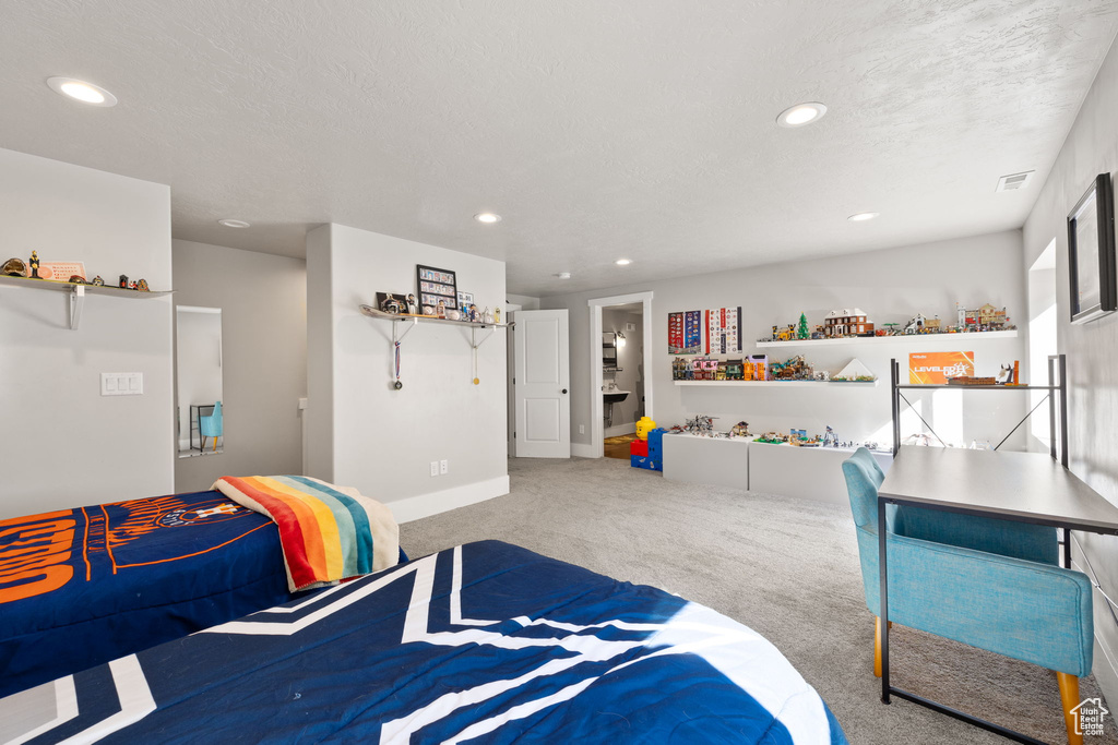 Carpeted bedroom featuring recessed lighting and a textured ceiling