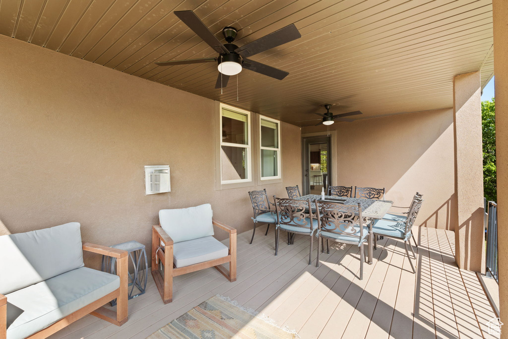 Wooden deck featuring outdoor dining area and ceiling fan