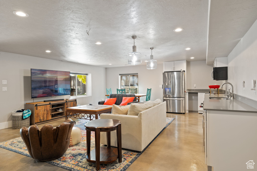 Living area featuring recessed lighting, concrete flooring, and a textured ceiling
