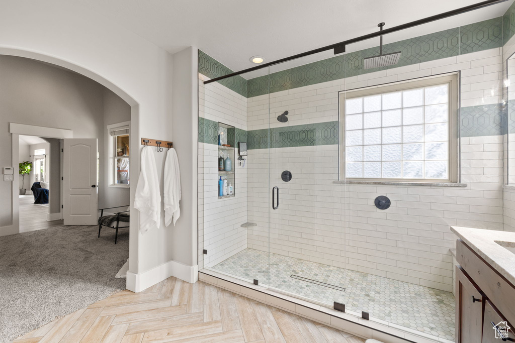Bathroom featuring a stall shower, baseboards, vanity, and baseboard heating