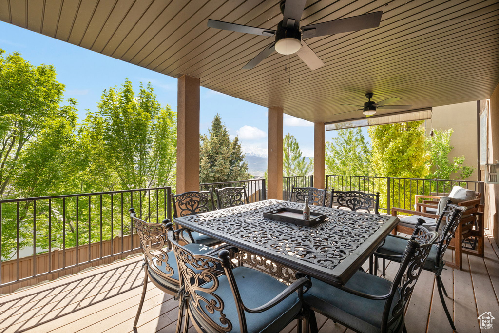 Deck with outdoor dining space and a ceiling fan